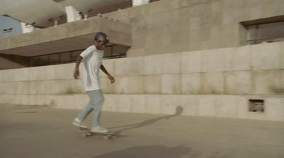 a man riding a skateboard down a sidewalk