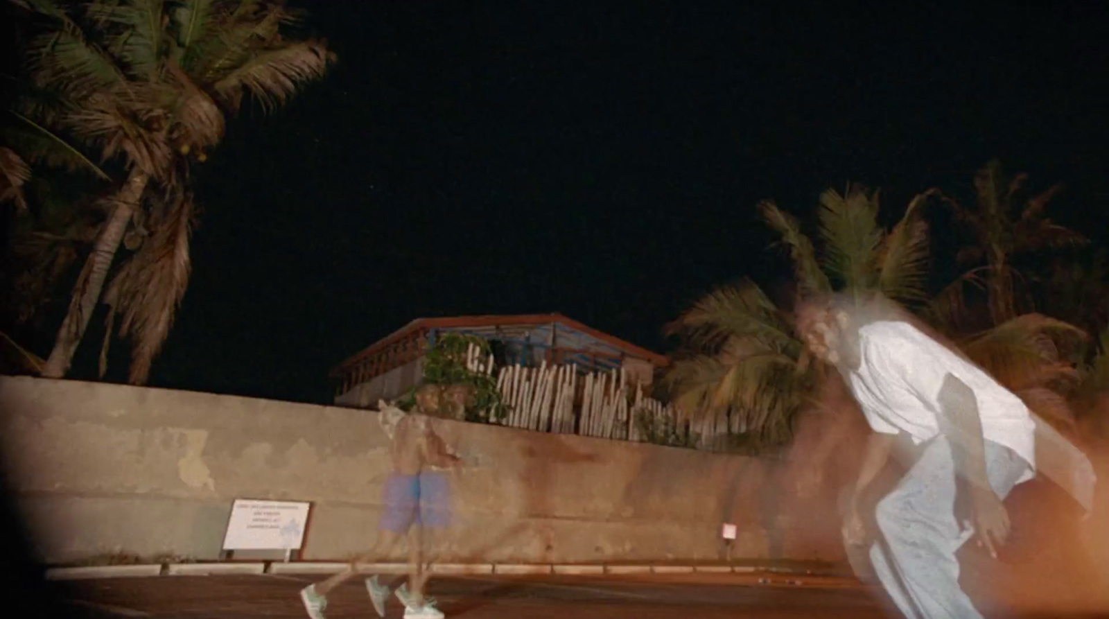 a man riding a skateboard down a street at night