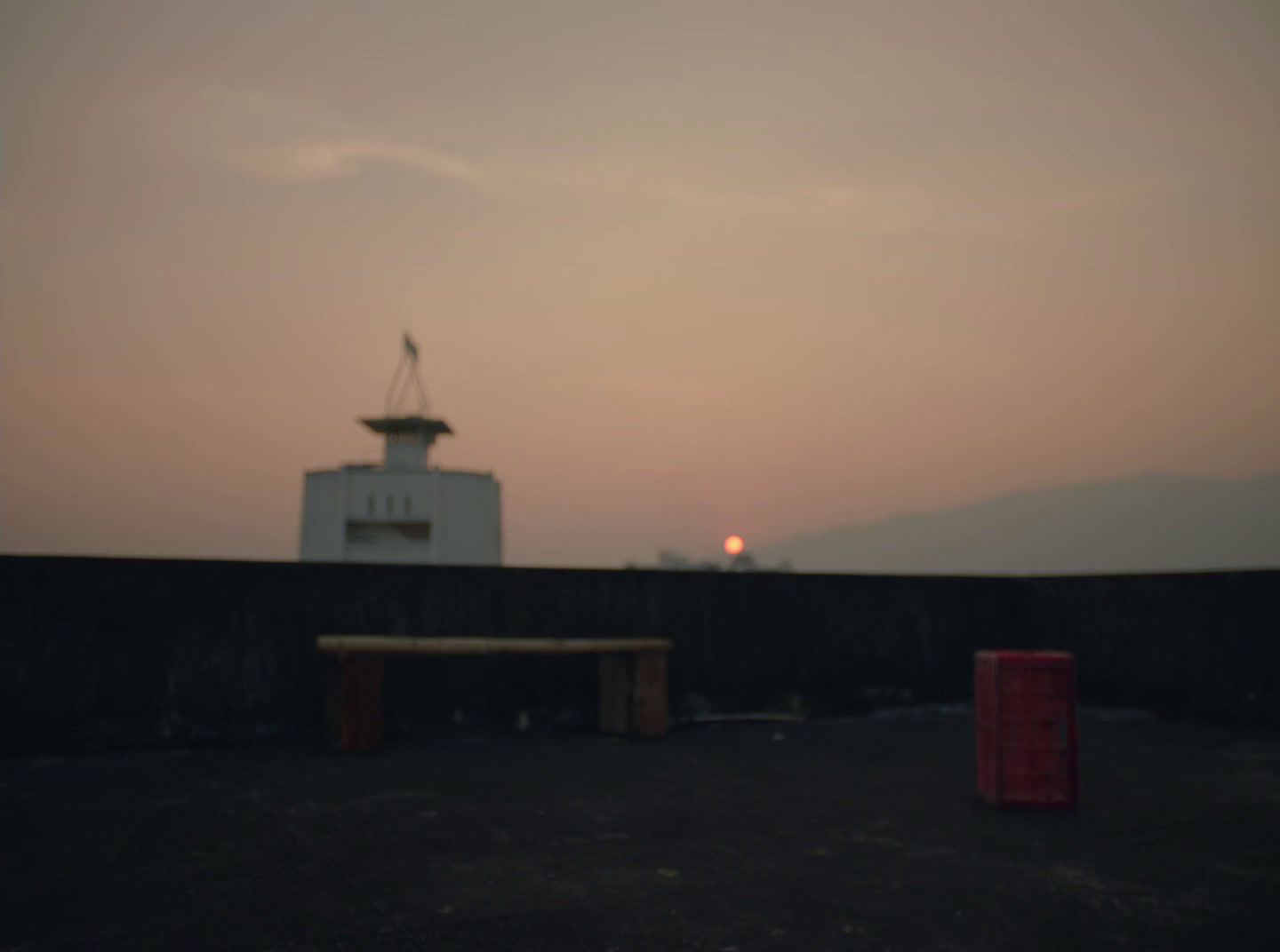 a small white building sitting next to a fence