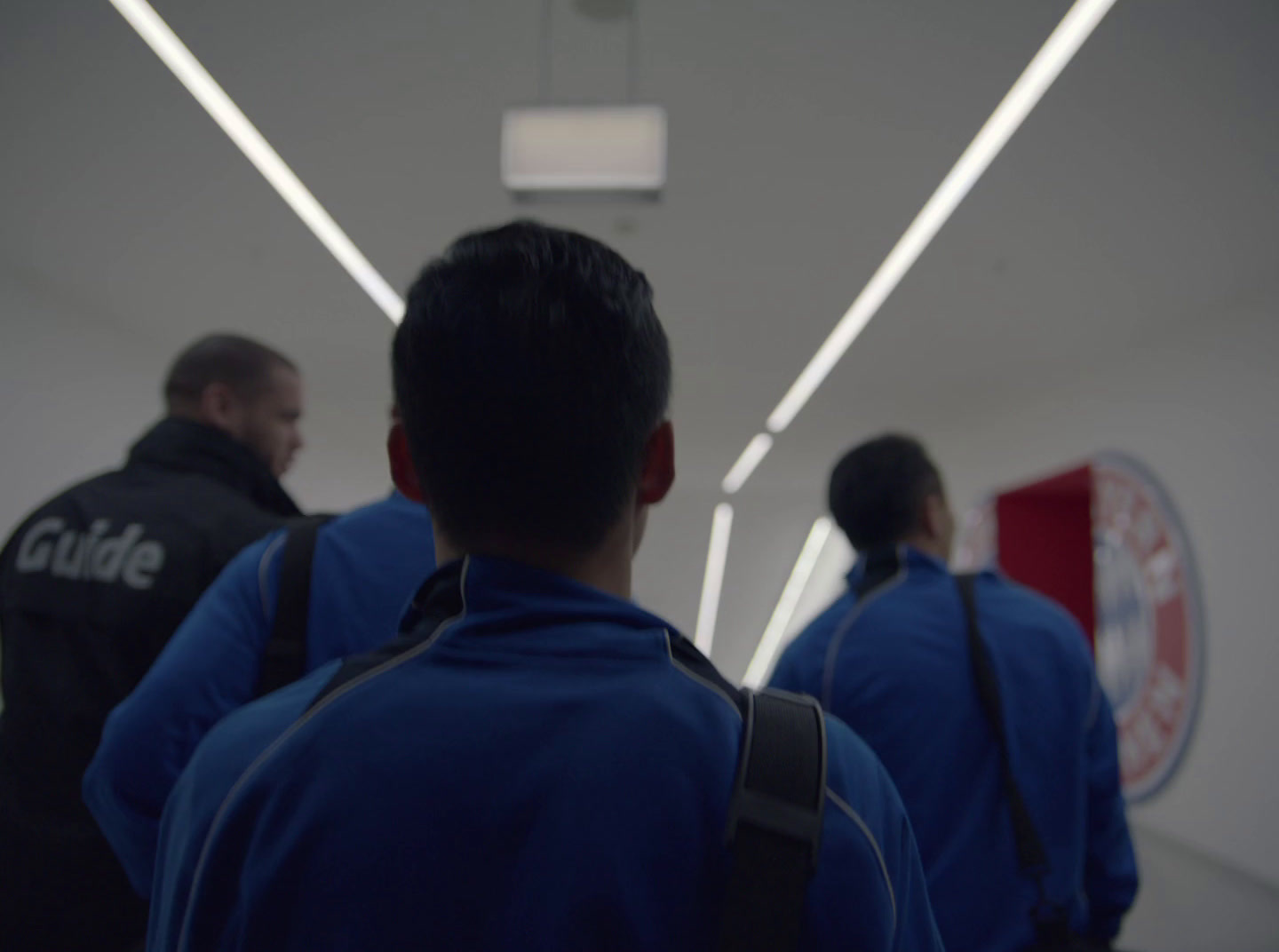 a group of men walking down a hallway