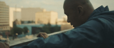 a man looking out a window at a city