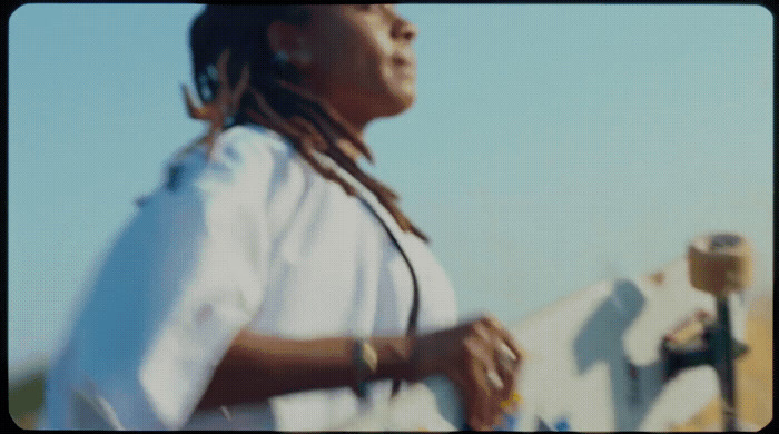 a woman with dreadlocks walking down a street