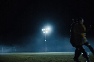 a couple of people standing on top of a soccer field