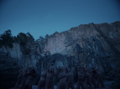 a group of naked people standing in front of a mountain