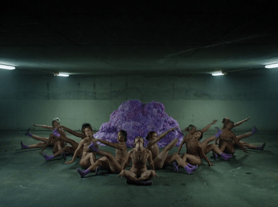 a group of naked women sitting on the ground