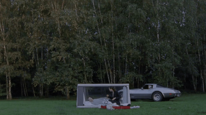 a car is parked next to a tent in the grass