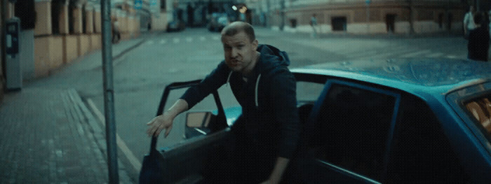 a man leaning out of a car on a city street