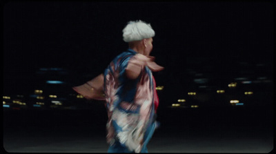 a man in a kimono is dancing in the dark