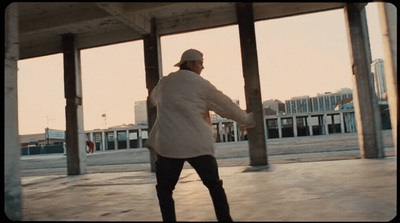 a man riding a skateboard under a bridge