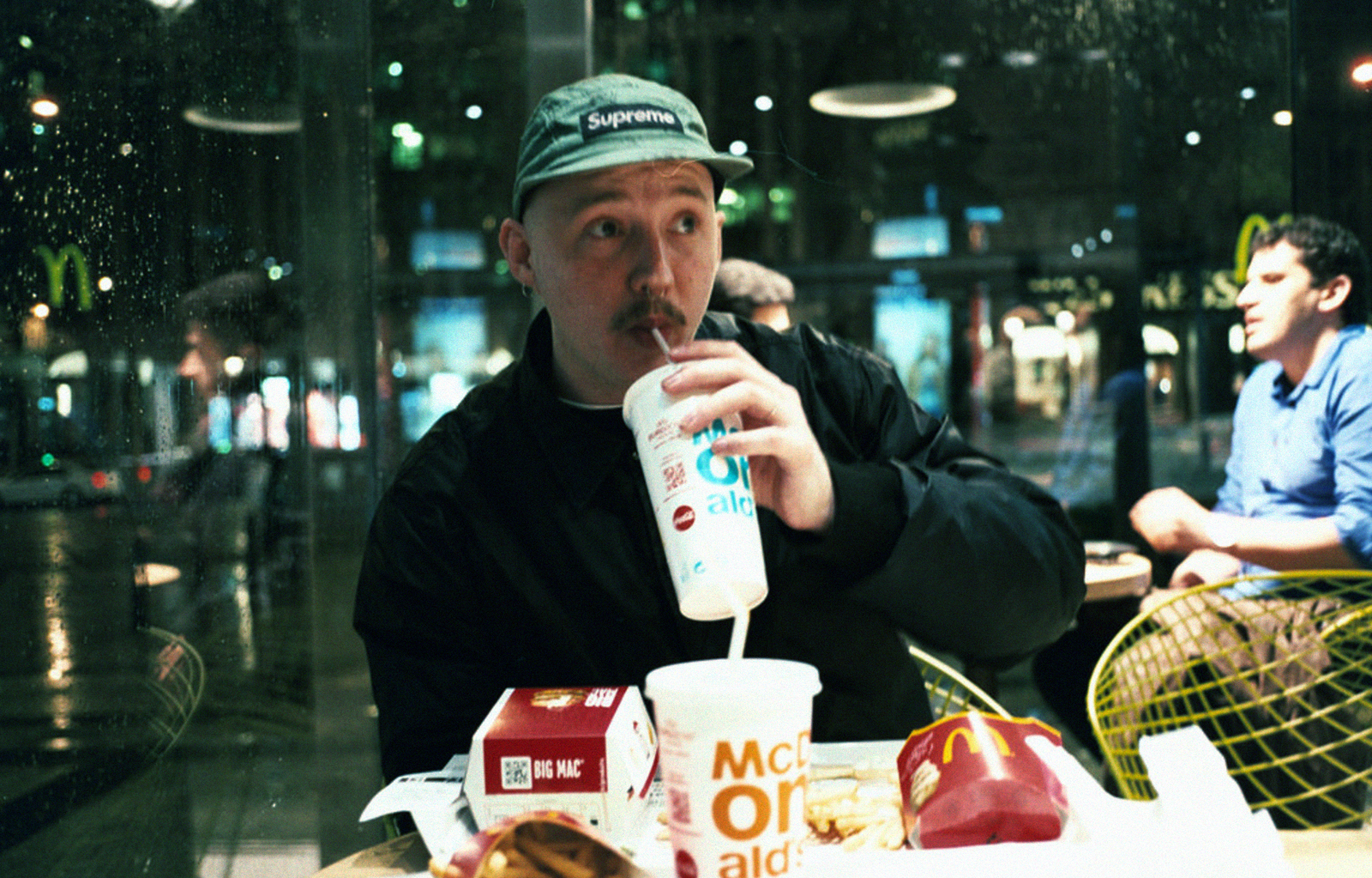 a man sitting at a table with a bottle of milk