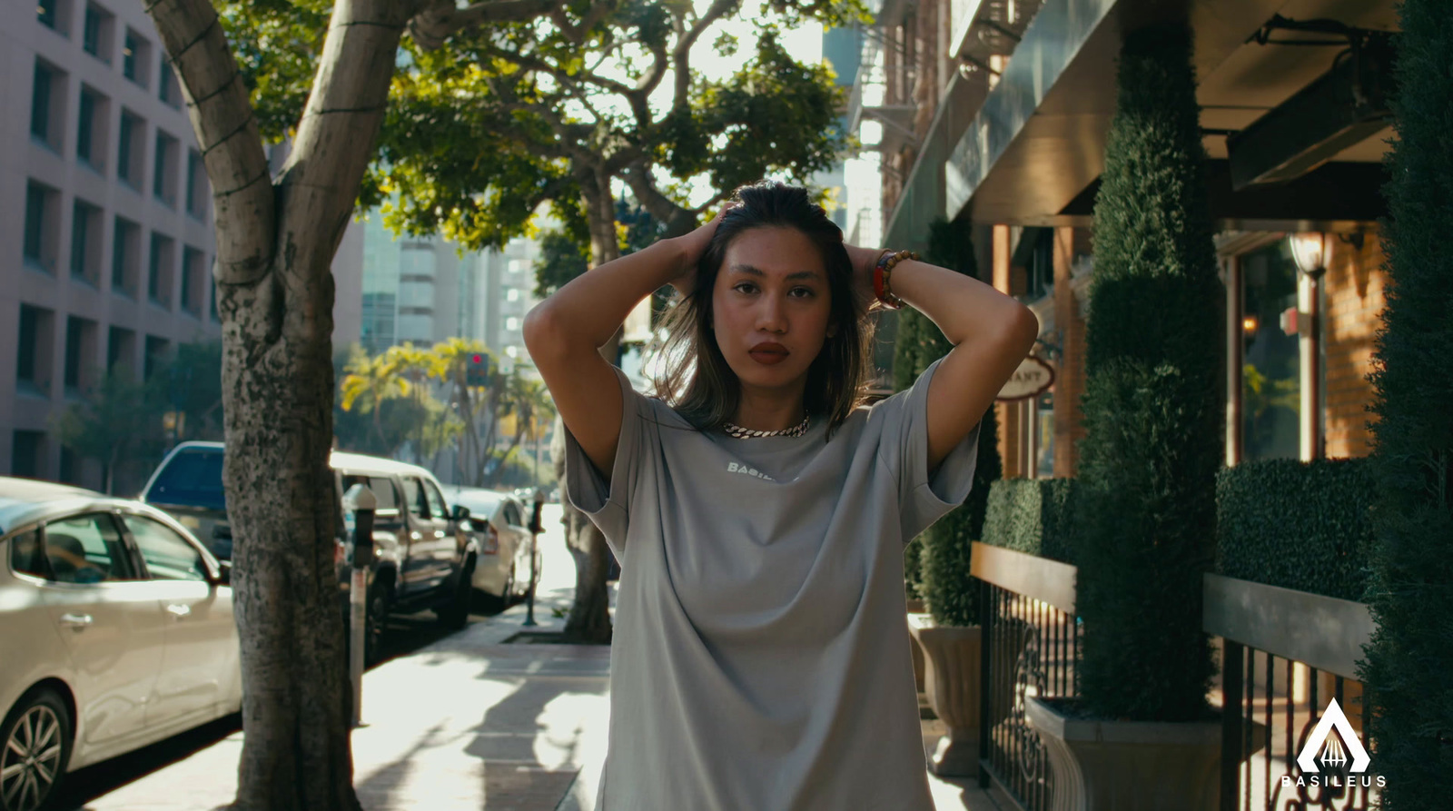 a woman standing on a sidewalk with her hands on her head