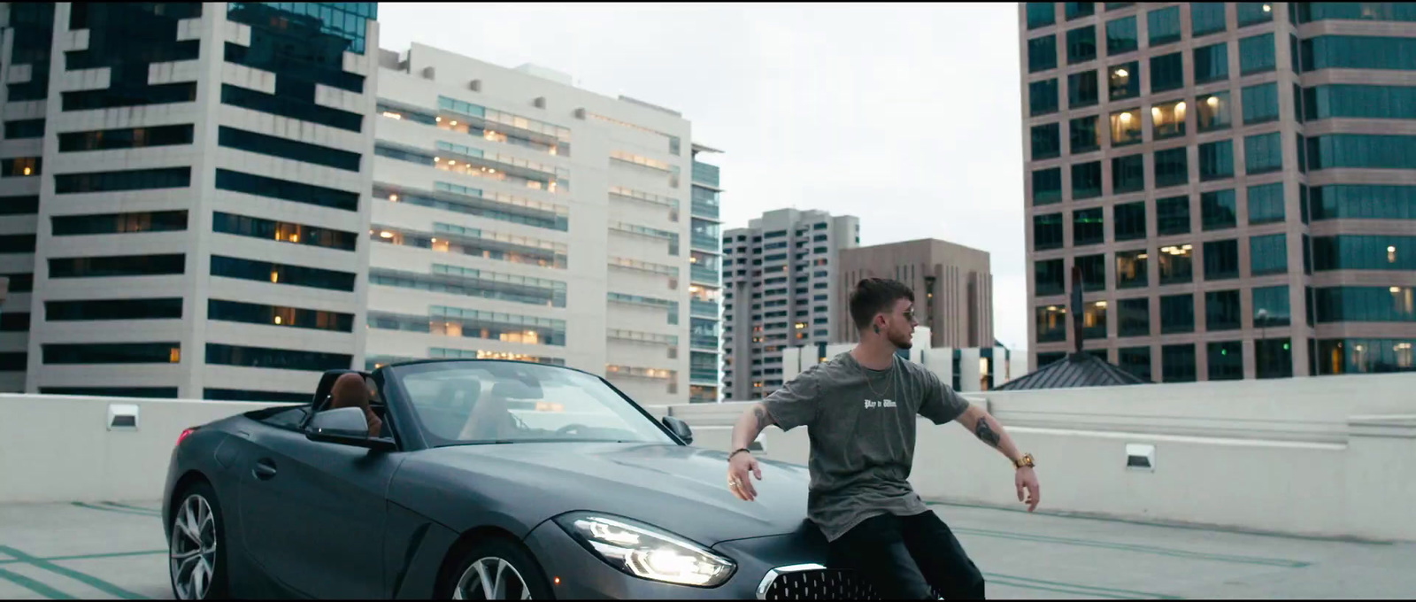 a man standing next to a car in a parking lot