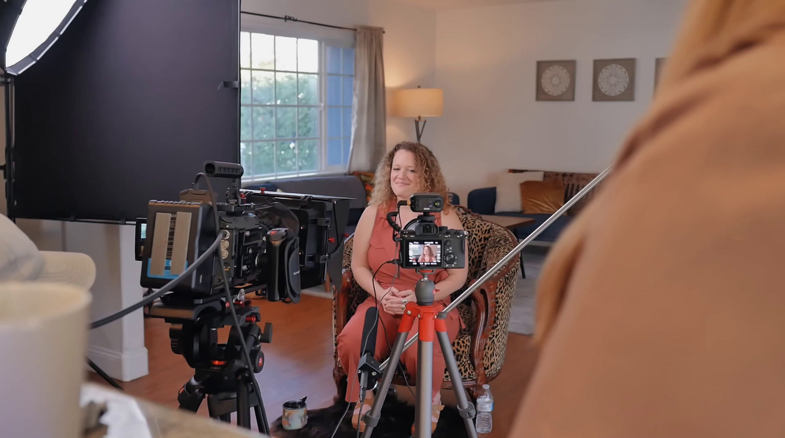 a woman sitting in a chair in front of a camera