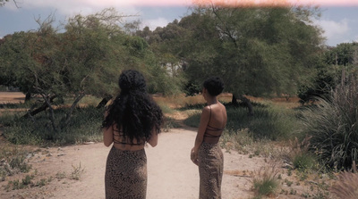 a couple of women standing on a dirt road