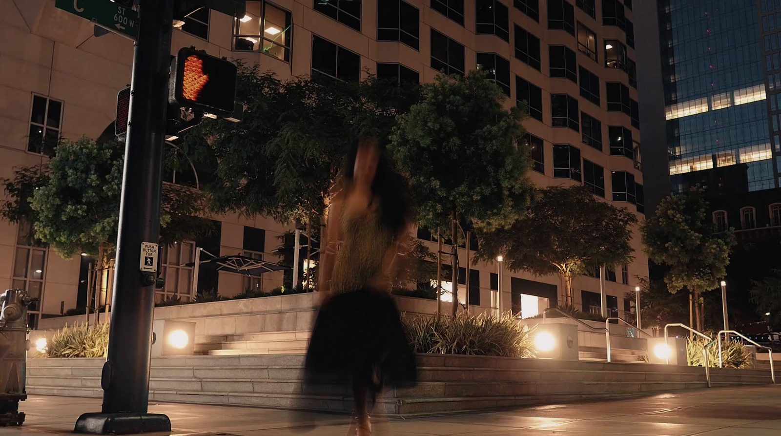 a woman walking down a street at night