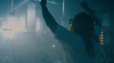 a man with dreadlocks standing in front of a crowd