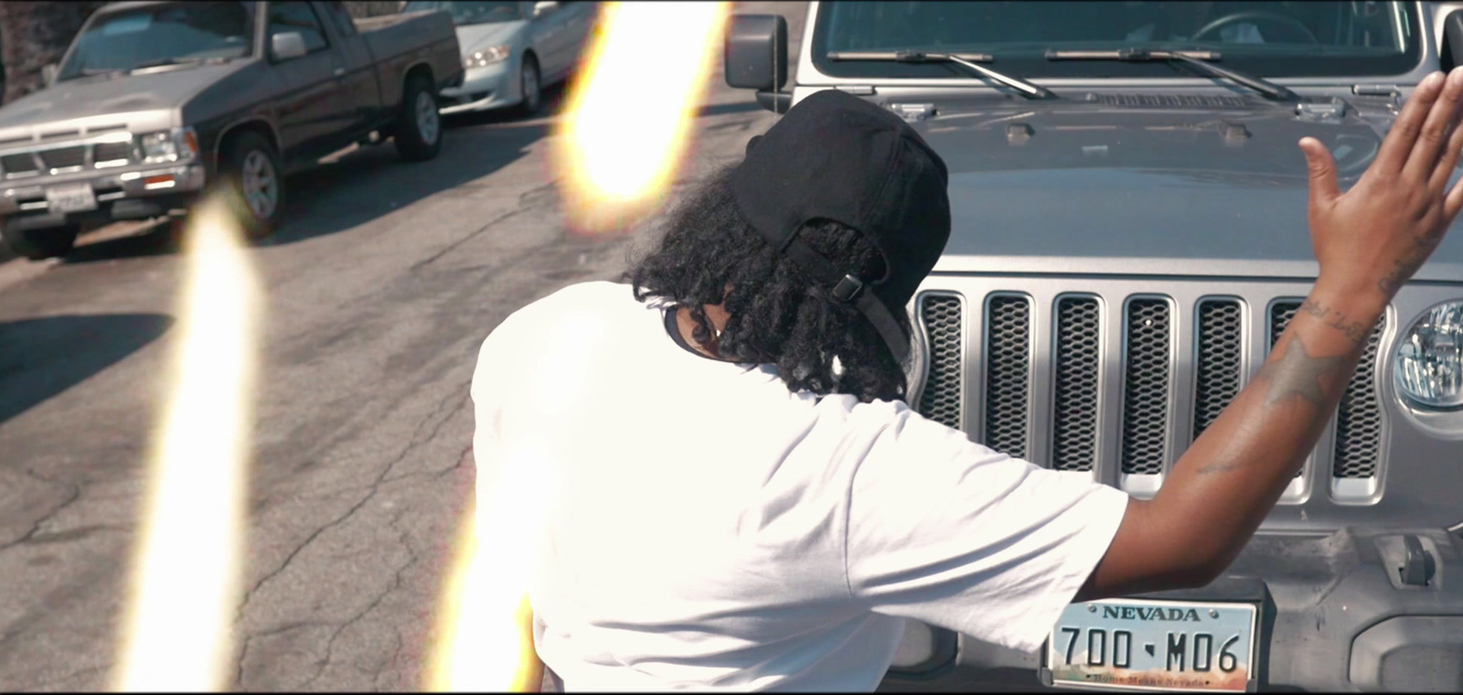 a man in a white shirt and a black hat on a street