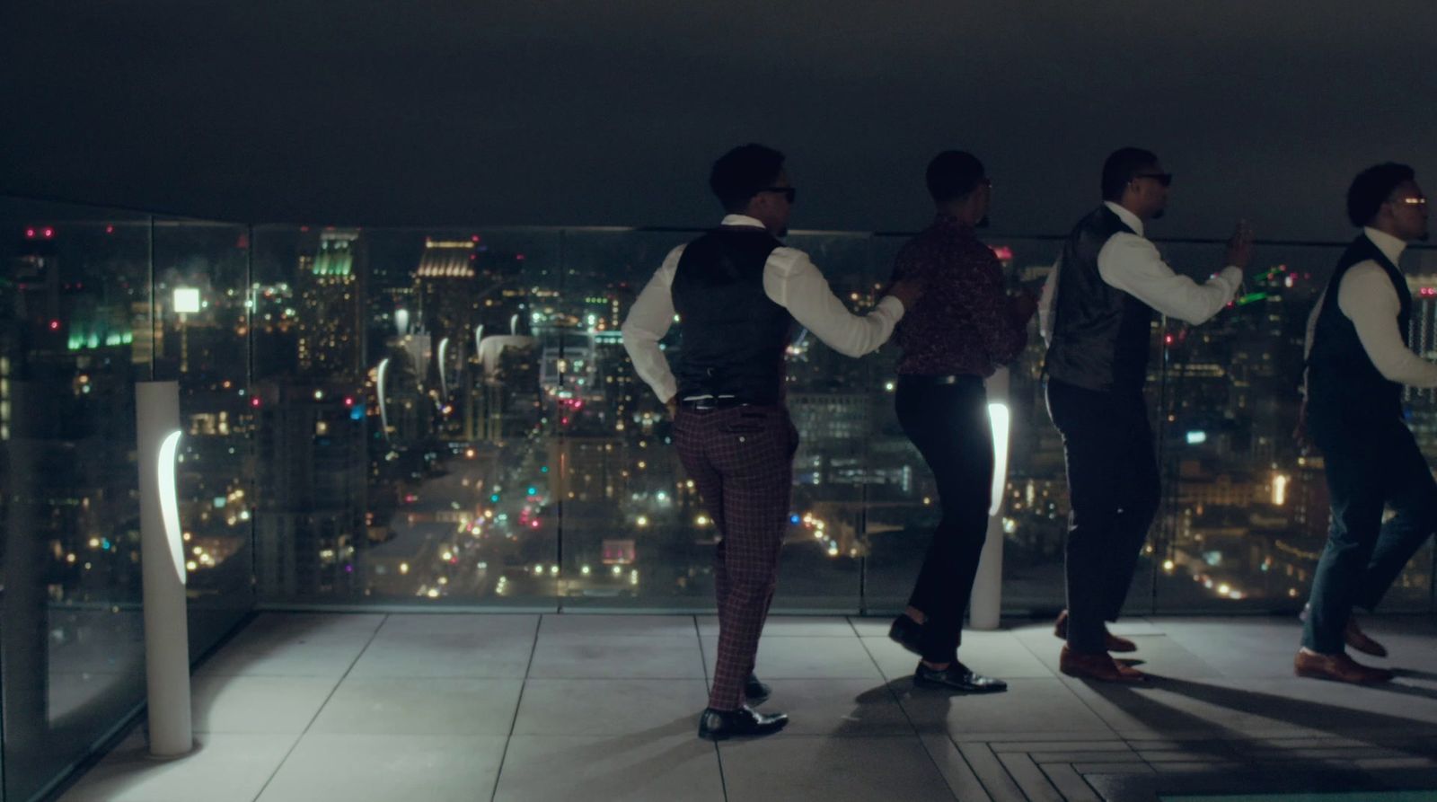 a group of men standing on top of a building