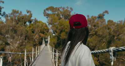 a woman wearing a red hat standing on a bridge