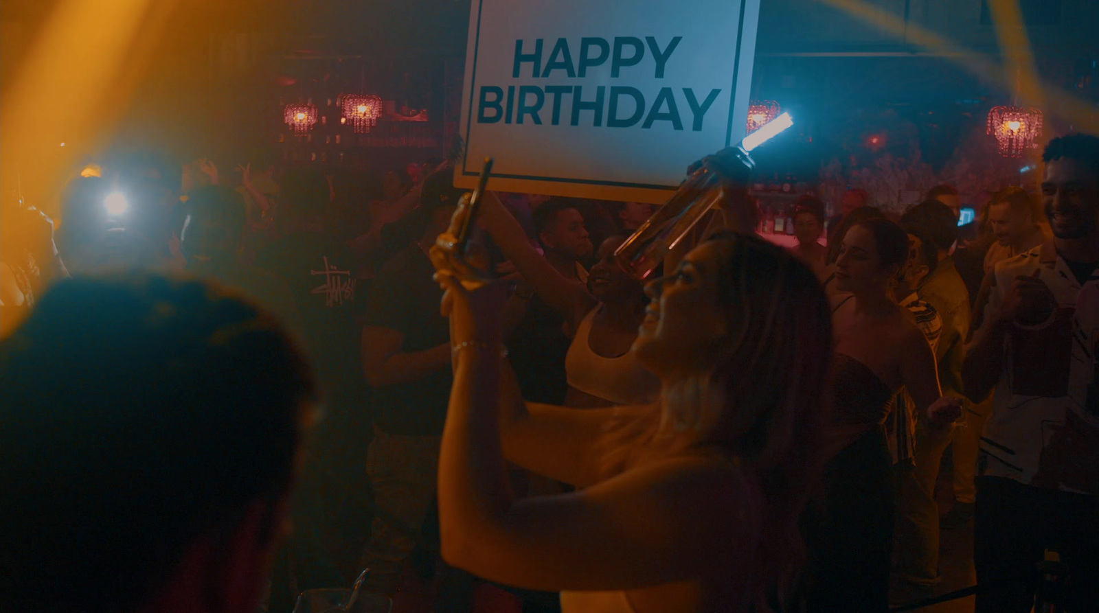 a woman holding a sign that says happy birthday