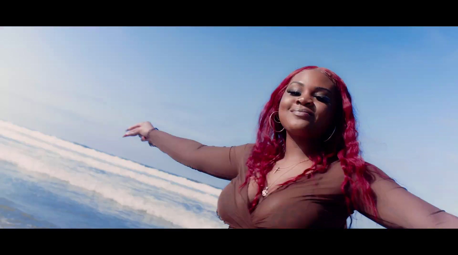 a woman with red hair standing in front of a body of water