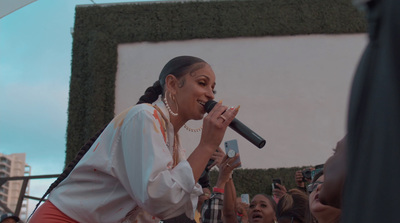 a woman singing into a microphone in front of a crowd