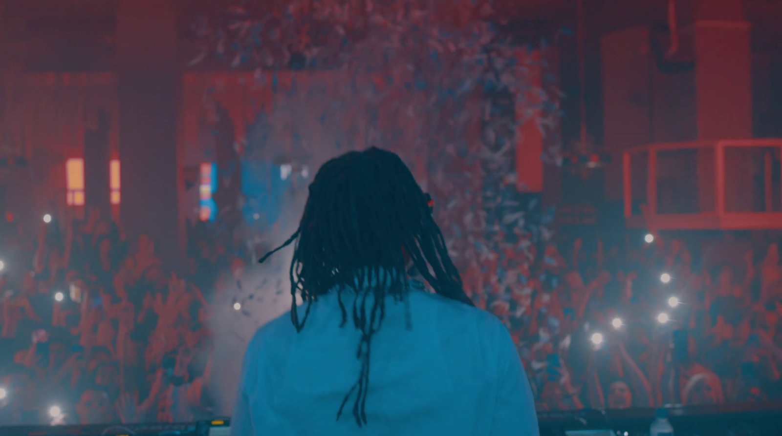 a man with dreadlocks standing in front of a crowd