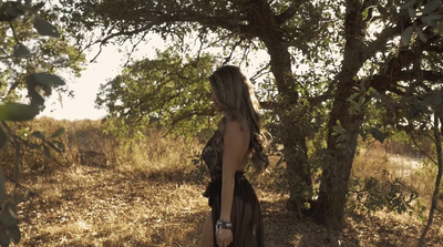 a woman in a black dress standing in a field