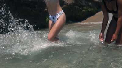 two women in bathing suits playing in the water