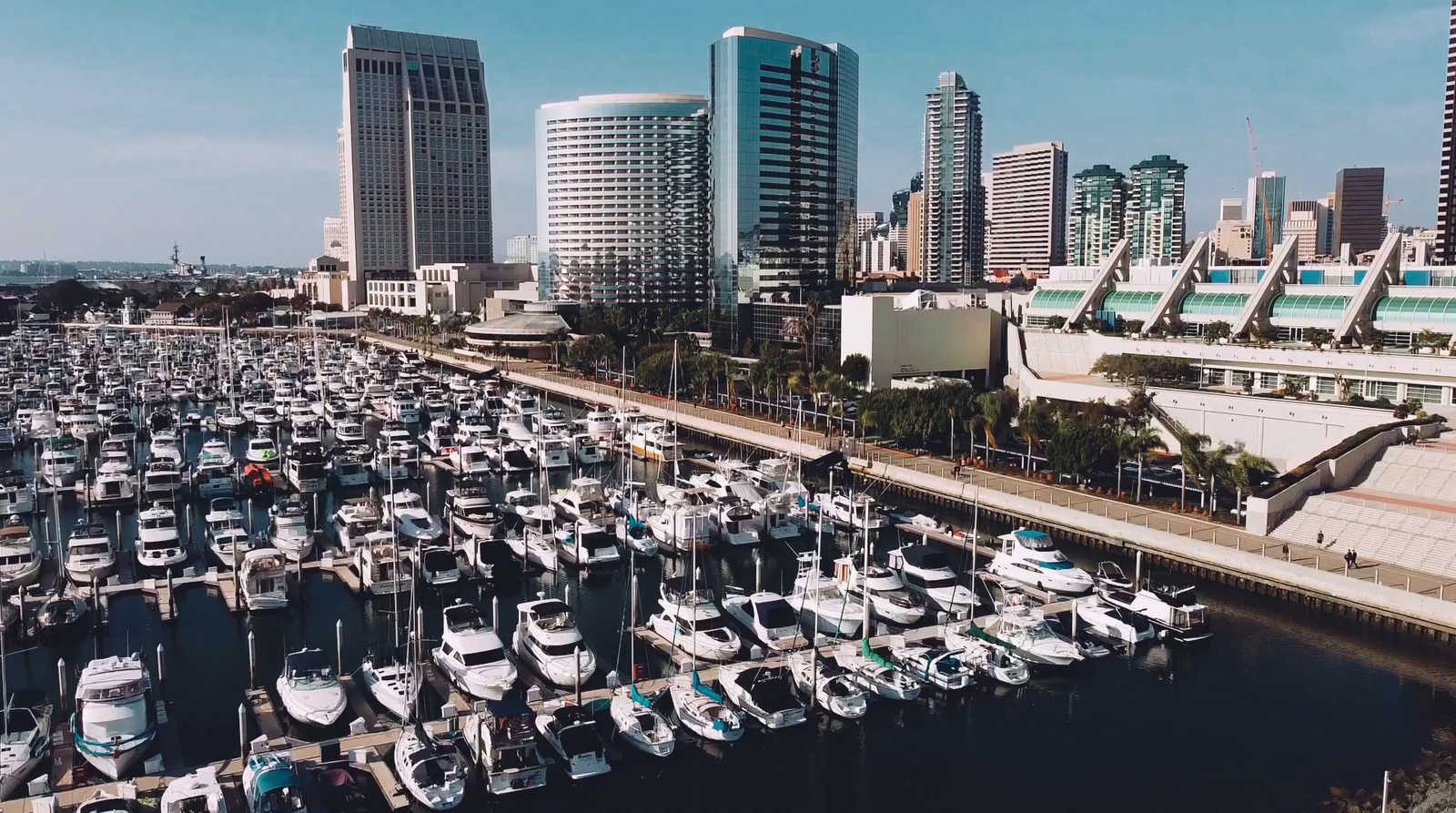 a harbor filled with lots of boats next to tall buildings