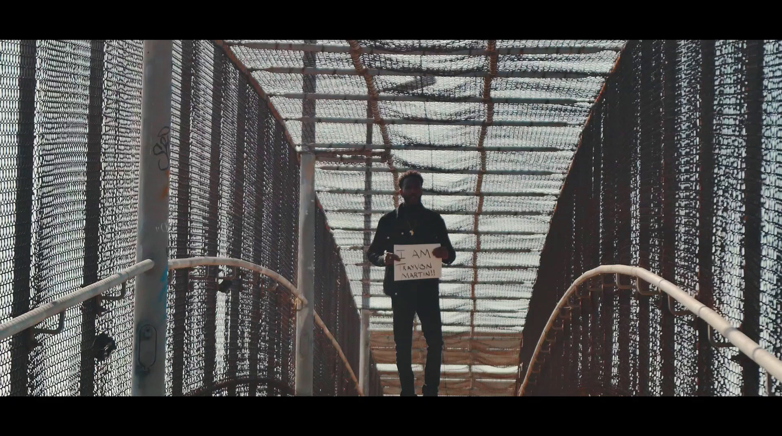 a man standing on a bridge holding a paper