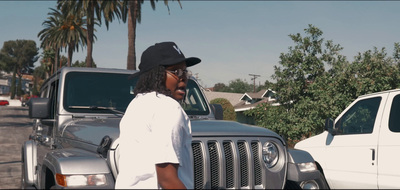 a man standing in front of a truck talking on a cell phone