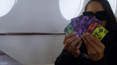 a woman holding up a bunch of cards in front of her face