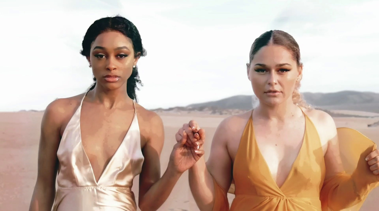 two women standing next to each other in a desert