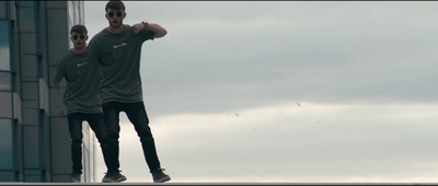 a couple of men standing on top of a tall building