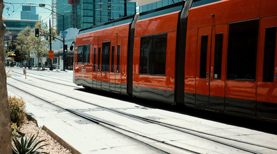 a red train traveling down train tracks next to a tall building