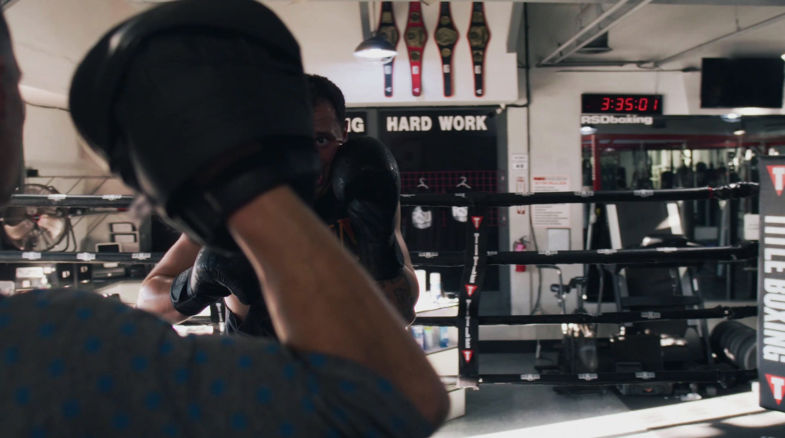 a man taking a picture of a man in a boxing ring