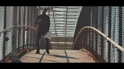 a man is standing on a metal bridge