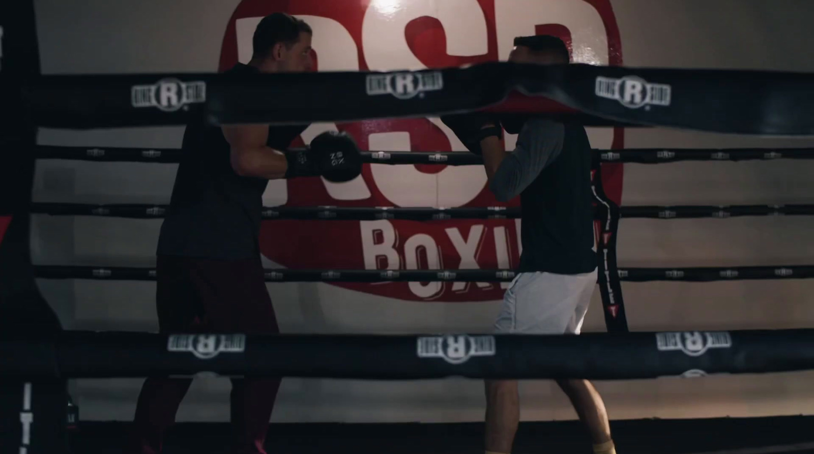 a couple of men standing next to each other in a boxing ring