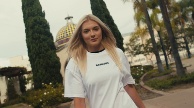 a woman in a white t - shirt is walking down the street