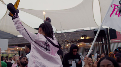 a woman holding up a flag in front of a crowd