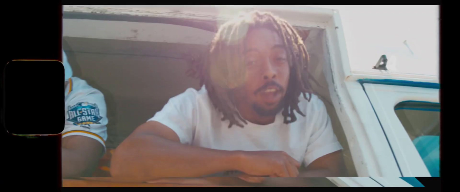 a man with dreadlocks sitting at a table