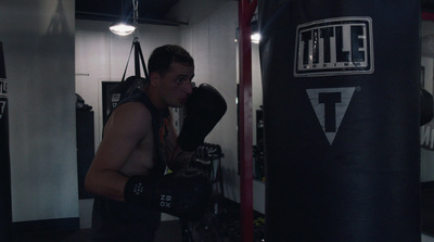 a man standing next to a punching bag