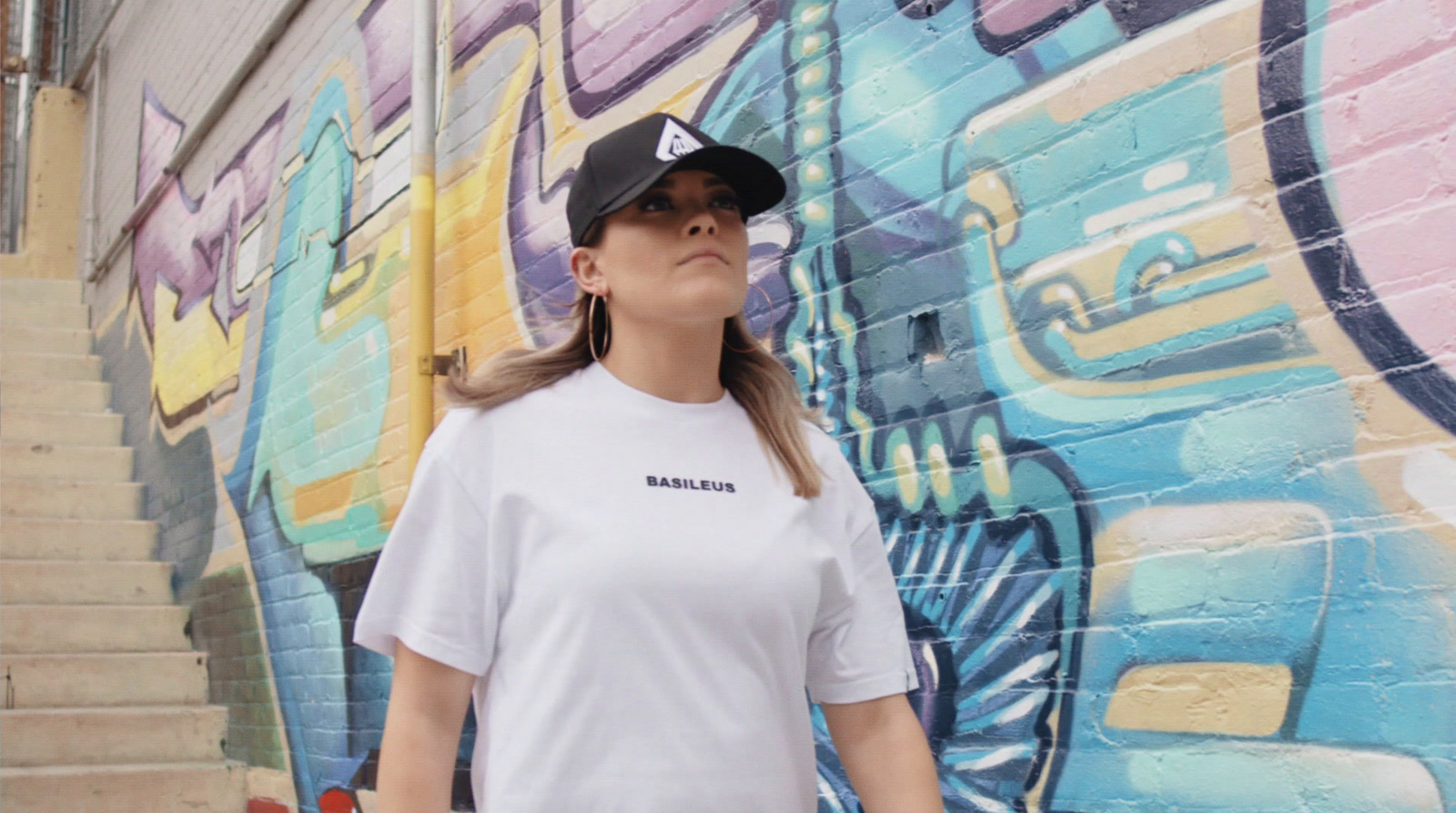 a woman standing in front of a colorful wall