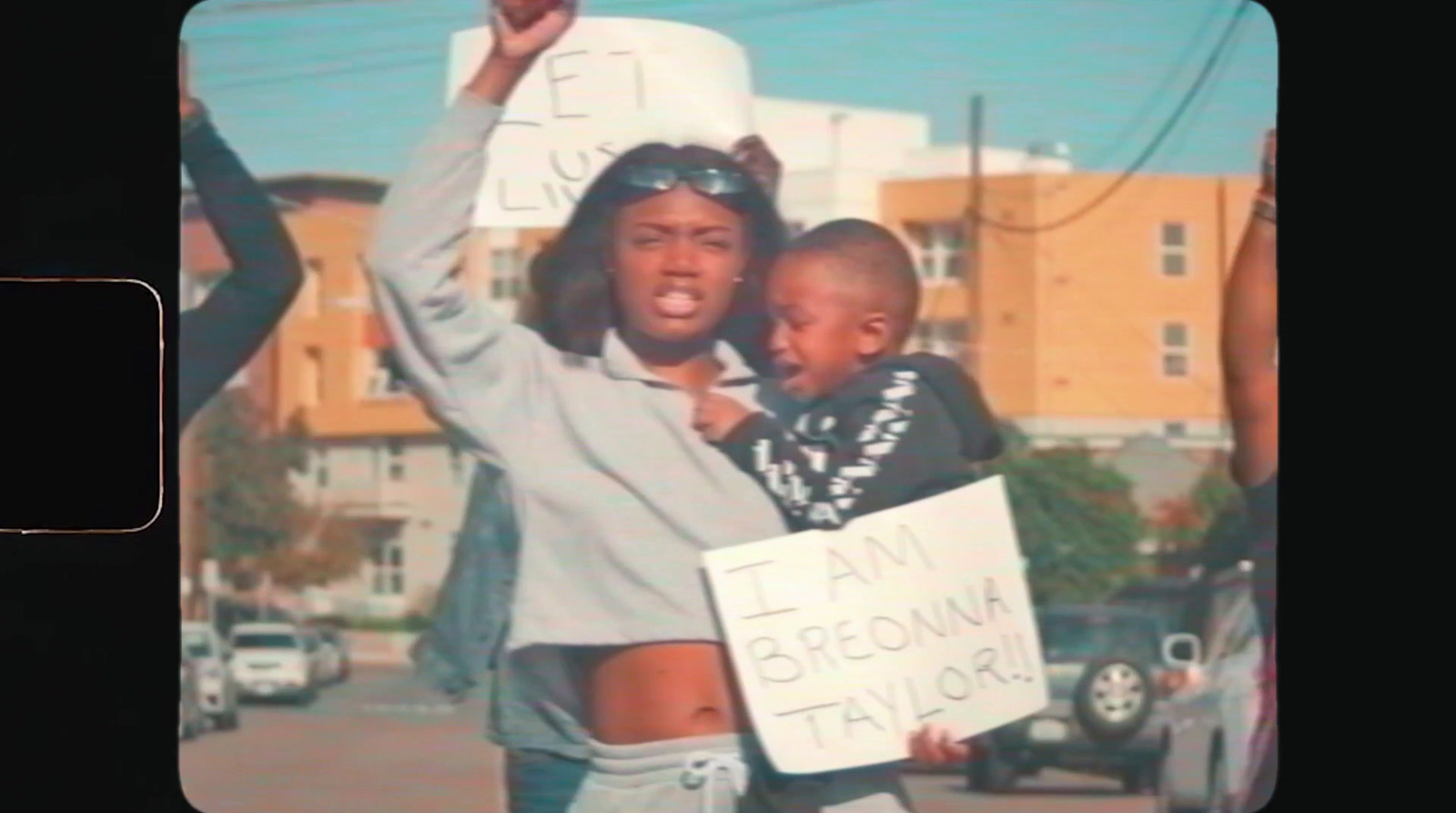 a woman holding a child and a sign