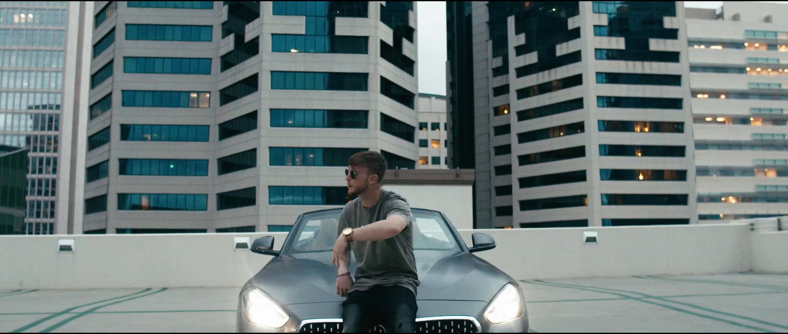 a man sitting on the hood of a car