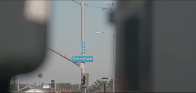 a blue street sign hanging from a traffic light