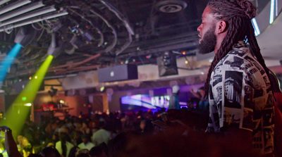 a man with dreadlocks standing in front of a crowd