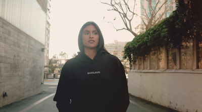 a woman in a black hoodie standing on a street