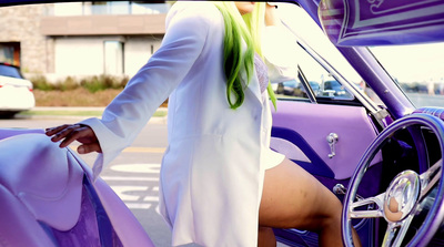 a woman with green hair sitting in a car